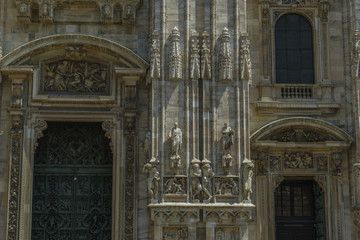 Obraz premium Milan, Italy Duomo facade detail. Ornate features and artwork on front entrance of Milano Roman Catholic Cathedral.