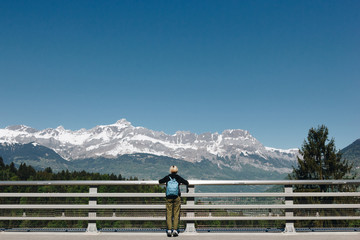 Fototapeta na wymiar back view of girl with backpack looking at majestic snow-capped mountains, mont blanc, alps