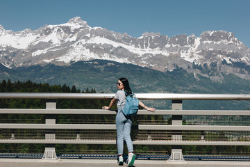 Fototapeta na wymiar back view of young woman with backpack standing in beautiful scenic mountains, mont blanc, alps