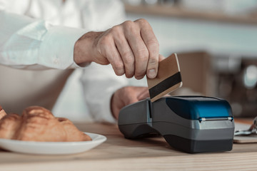 Check payment. Close up of businessman that standing at his workplace while using credit card