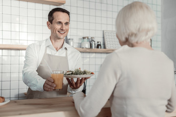 Keep fit. Joyful man keeping smile on face while demonstrating good service