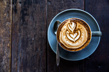 Cup of hot latte coffee on wooden table
