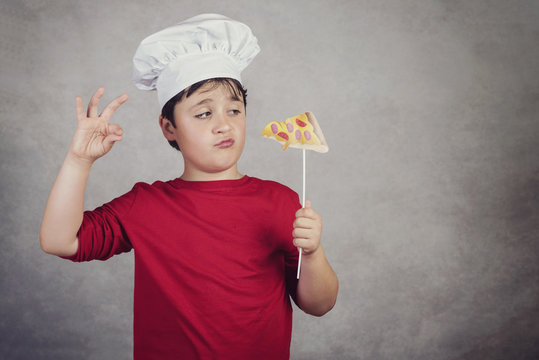 niño cocinero gracioso con un trozo pizza