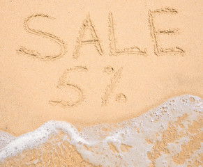 The word Sale 5% written in the sand on beach