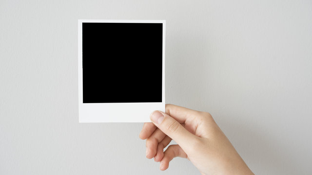 Hand holding blank photo frame