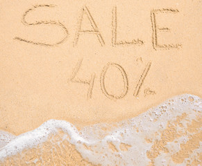 The word Sale 40% written in the sand on beach