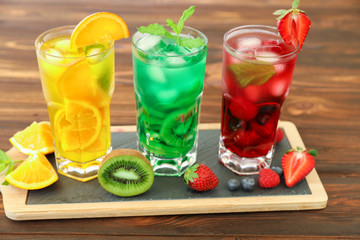 Three glasses of different cold summer drinks or refreshing cocktails yellow, green, red in toxic colors.