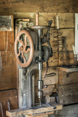 Vintage stand up drill in the garage workshop.
