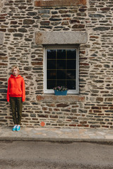 Fototapeta na wymiar young woman standing near old stone building, mont saint michel, france