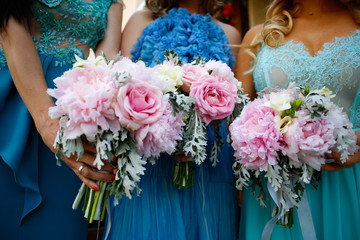 Bridesmaids in blue dress holding bouquet of flowers