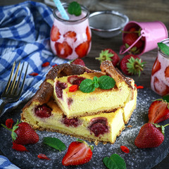 pieces of cheesecake with strawberries on a black graphite plate