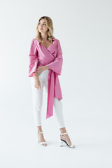 thoughtful young woman in pink blouse posing isolated on white