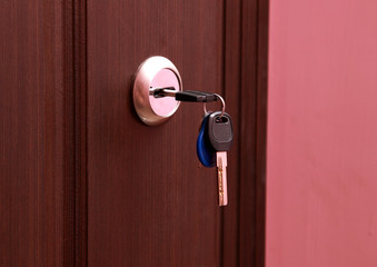 Close-up photography. The keys are in the keyhole of the front door.