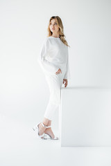 young beautiful blond woman in white clothing posing isolated on white