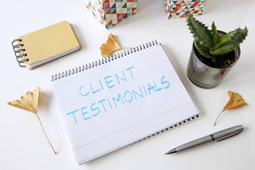 client testimonials written in a notebook on white table - obrazy, fototapety, plakaty