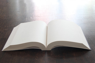 open book with empty pages on a wooden table with copy space