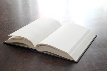 open book with empty pages on a wooden table with copy space