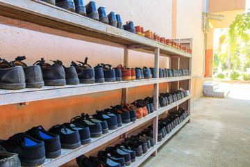 The student's shoes on the wooden shelf in Thai rural primary school.