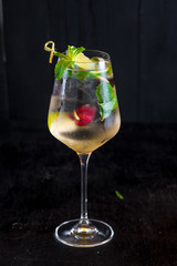 Fresh cold cocktail with lime and cherry on black background