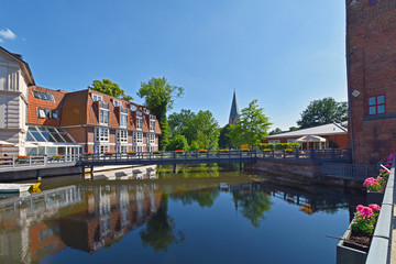 Obraz premium View on the river Ilmenau in the German medieval town of Lueneburg. The tower of the 