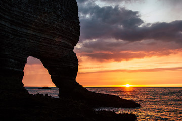 dramatic shot of rocky cliff on cloudy sunset, Etretat, France