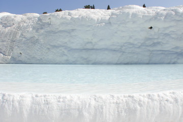 natural bathtub overfilled with pure mineral water; snow-white travertine rocks; famous healing springs in Pamukkale, T&uuml;rkiye