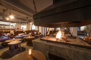 Fire in fireplace and setting tables in restaurant