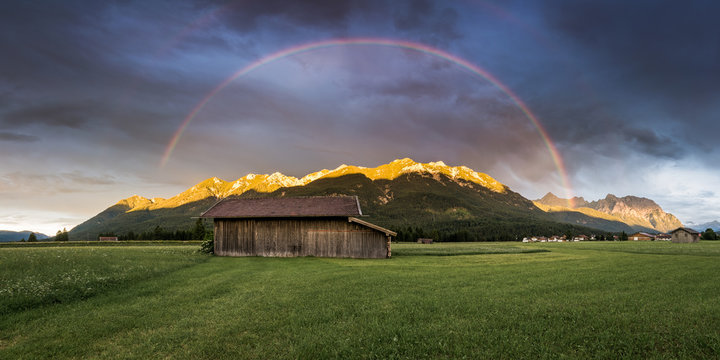 Regenbogen und Alpenglühen über den Bergen im Karwendel