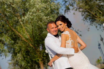 Beautiful Romantic Wedding Couple Of Newlyweds Hugging In Park On Sunset