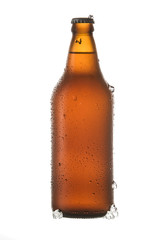 Cold beer with pieces of ice and drops by the bottle on white background