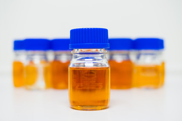 Broth media in the laboratory bottles placed on the white table and white background, concept of microbial laboratory in pharmaceutical industries.