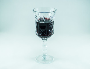 Closeup of a full engraved wine glass. Isolated on the white background.