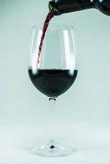 Bottle pouring a wine glass. Isolated on the white background. Isolated. Closeup.