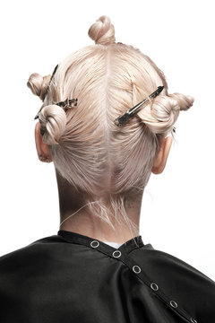 Hair coloring in blond. Preparation for hair cutting. Work stylist of the hairdresser in the salon on a white background.