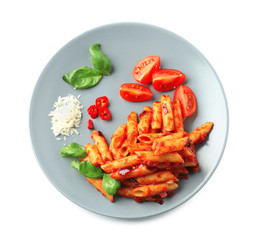 Plate with delicious penne pasta and garnish on white background