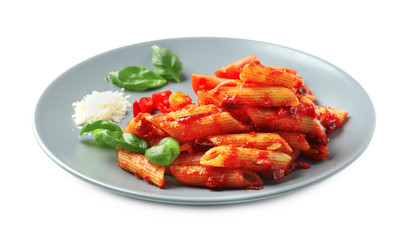 Plate with delicious penne pasta and garnish on white background