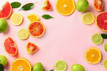 Composition with cut citrus fruits on color background, top view