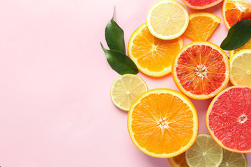 Composition with cut citrus fruits on color background, top view