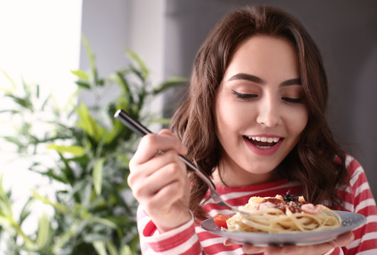 Young Woman Eating Tasty Pasta At Home