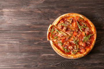 Tasty pizza with fresh arugula on wooden table
