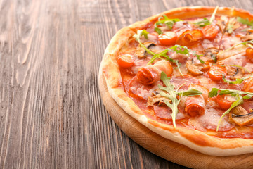 Tasty pizza with fresh arugula on wooden table