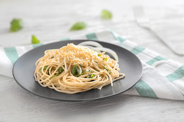 Plate of delicious pasta with cheese and herbs on white wooden table