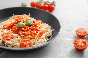 Frying pan with delicious pasta and tomato sauce on table, closeup