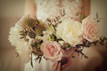 Wedding bouquet of white peony and coffee roses. Lots of greenery.