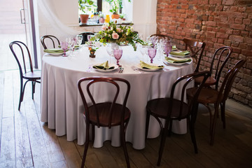Wedding banquet, loft style, served tables with flowers and lots of greenery.