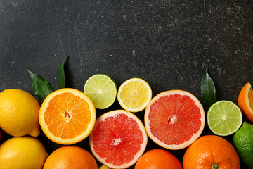 Ripe citrus fruits on gray background