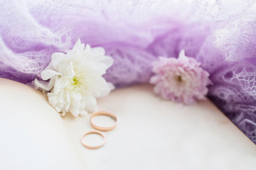 Pair of wedding rings. Retro background with old book and chrysanthemums.