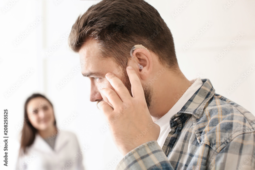 Wall mural Man with hearing aid in otolaryngologist's office