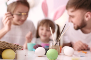 Obraz na płótnie Canvas Painted Easter eggs and blurred family on background