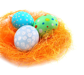 Decorative nest with colorful Easter eggs on white background